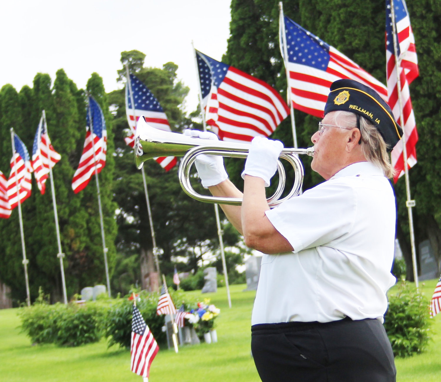 Donna Fanatia of the Charles Polton American Legion Post No. 427 in Wellman plays “Taps” during a brief Memorial Day ceremony at the Wellman cemetery Monday morning.